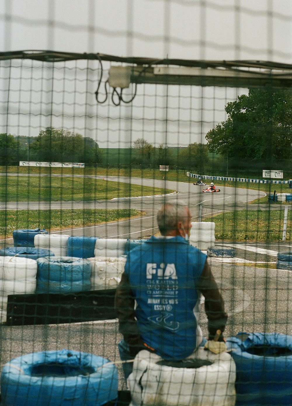 a man sitting on a bench in front of a fence