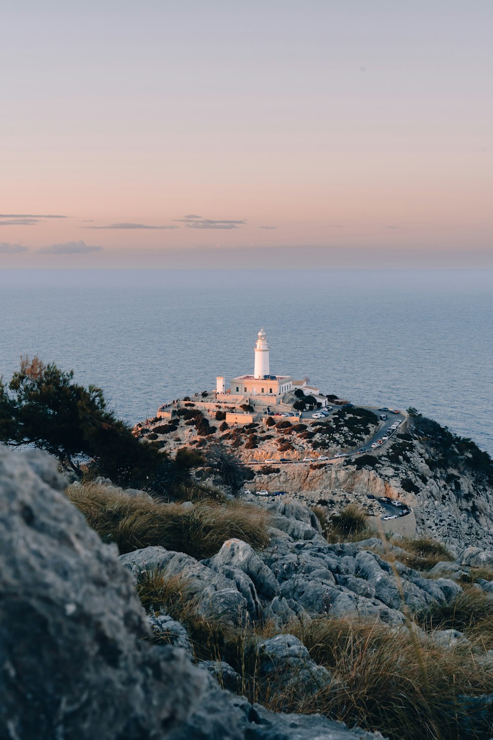 un phare au sommet d’une colline près de l’océan