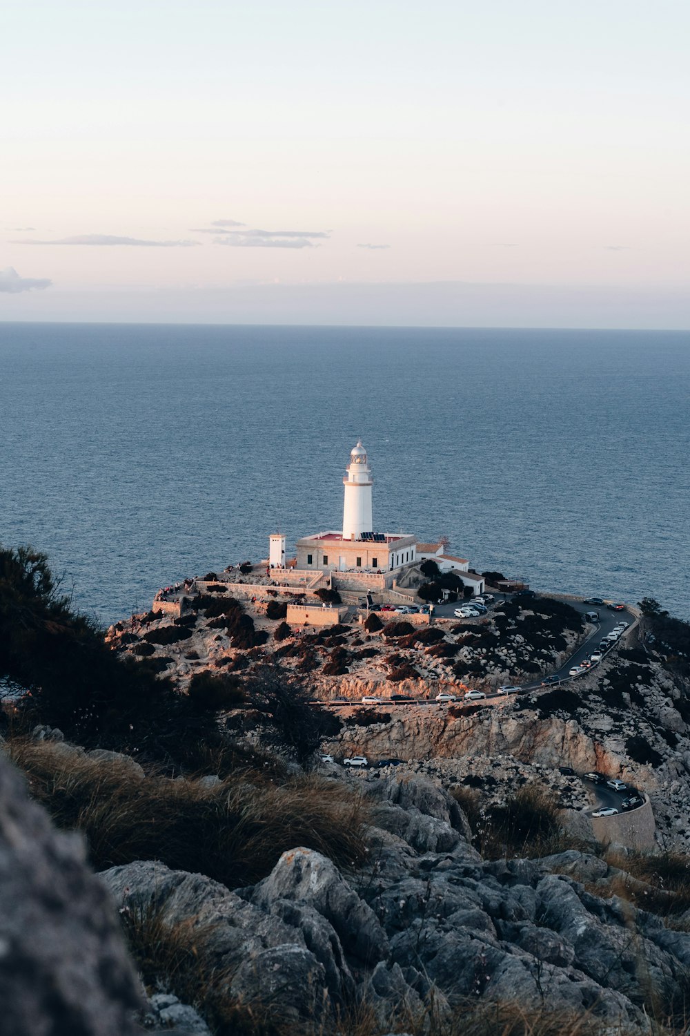 a lighthouse on top of a rocky hill near the ocean