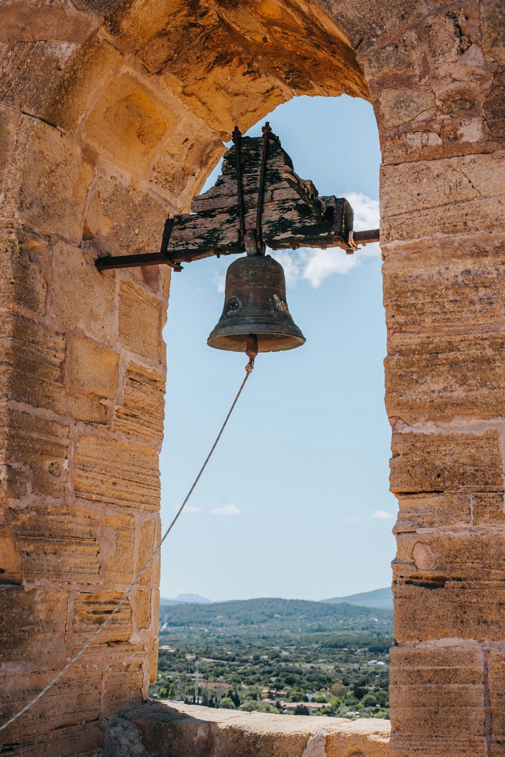 a bell hanging from the side of a stone building