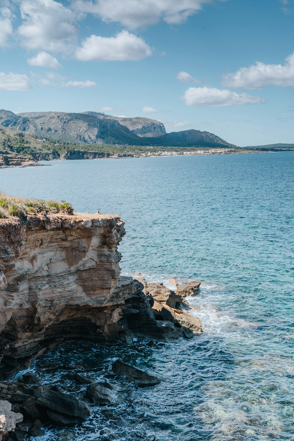 a large body of water next to a rocky cliff