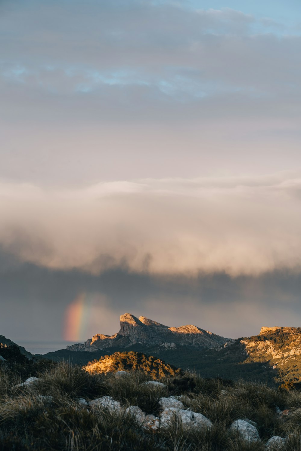 a rainbow in the sky over a mountain range