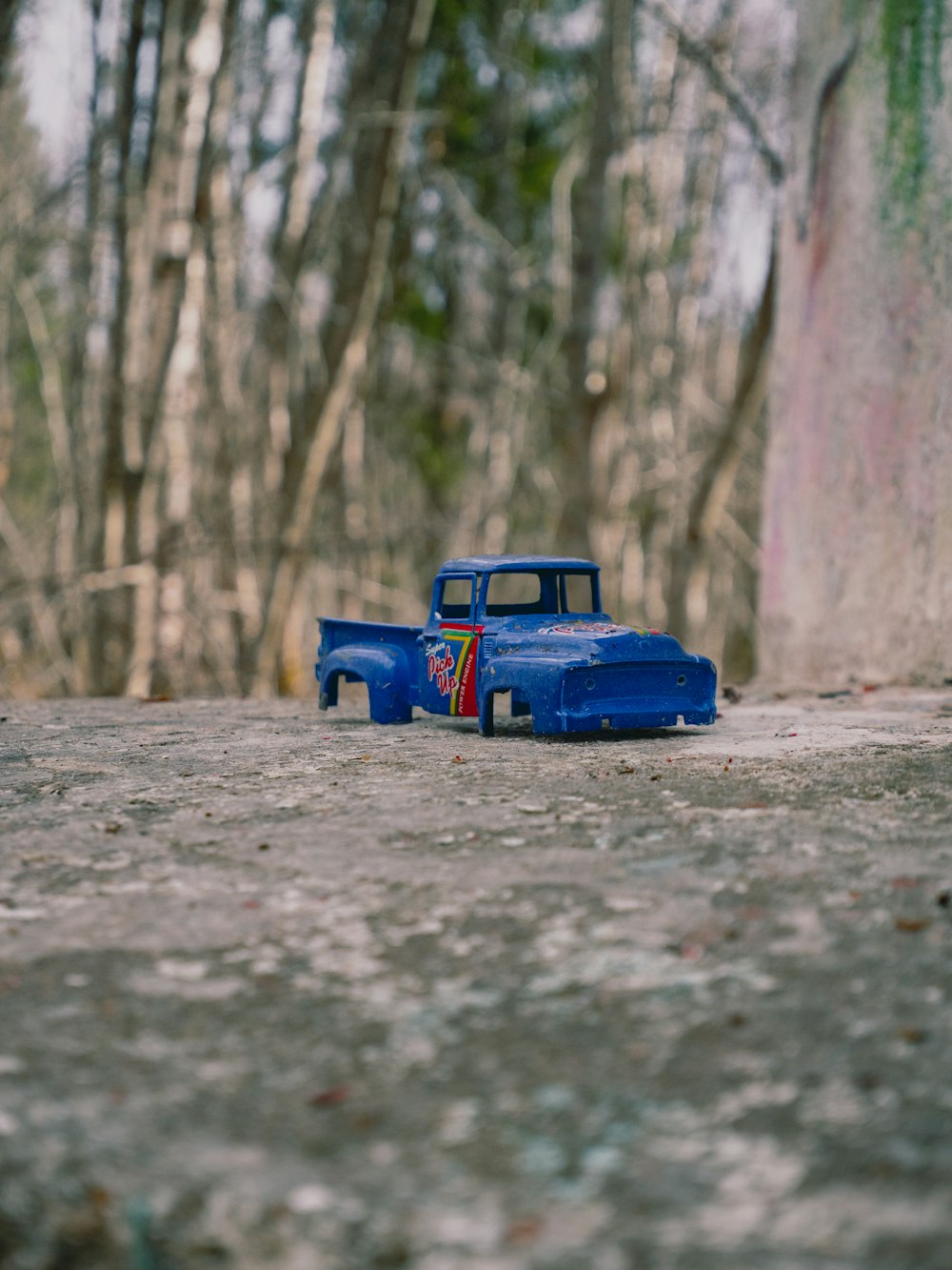 a toy truck sitting in the middle of a forest