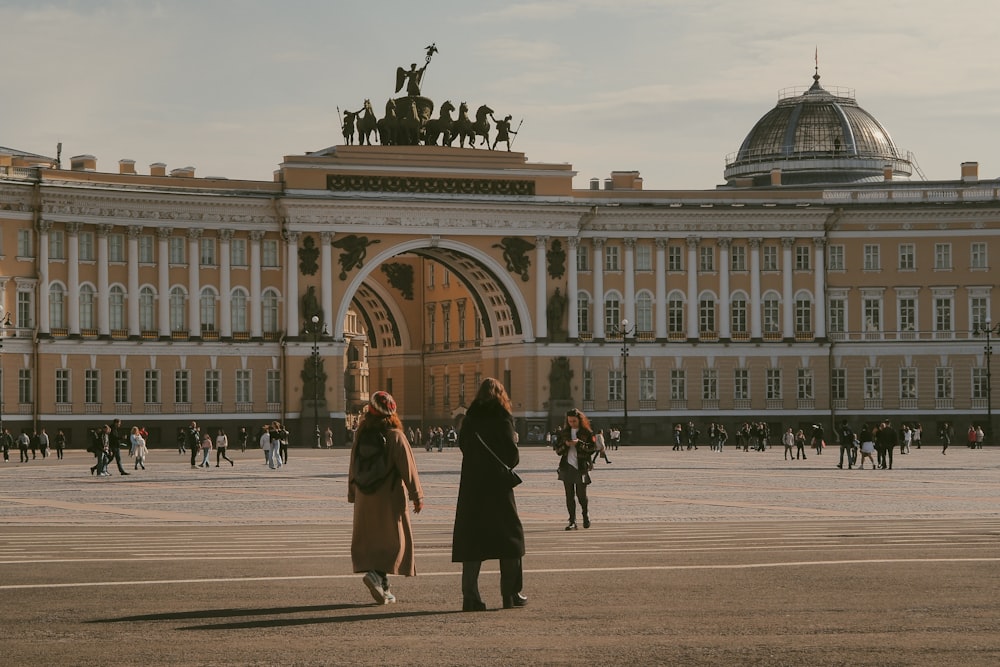 two women standing in front of a large building