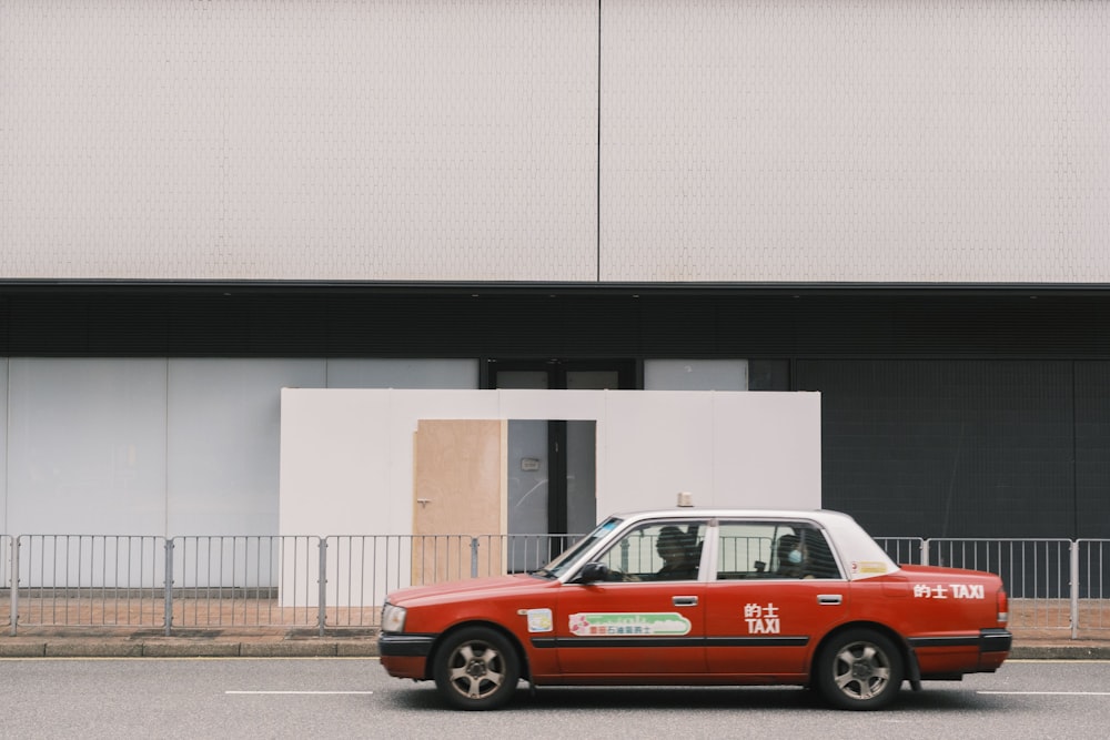 a red car is parked in front of a building