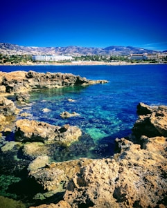 a body of water sitting next to a rocky shore
