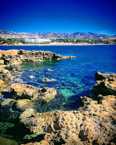 a body of water sitting next to a rocky shore