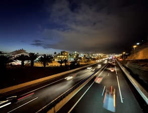 a night time view of a highway with a city in the background