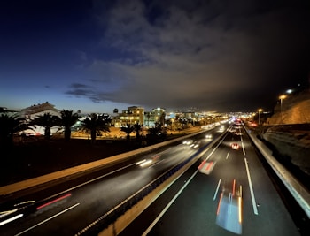 a night time view of a highway with a city in the background