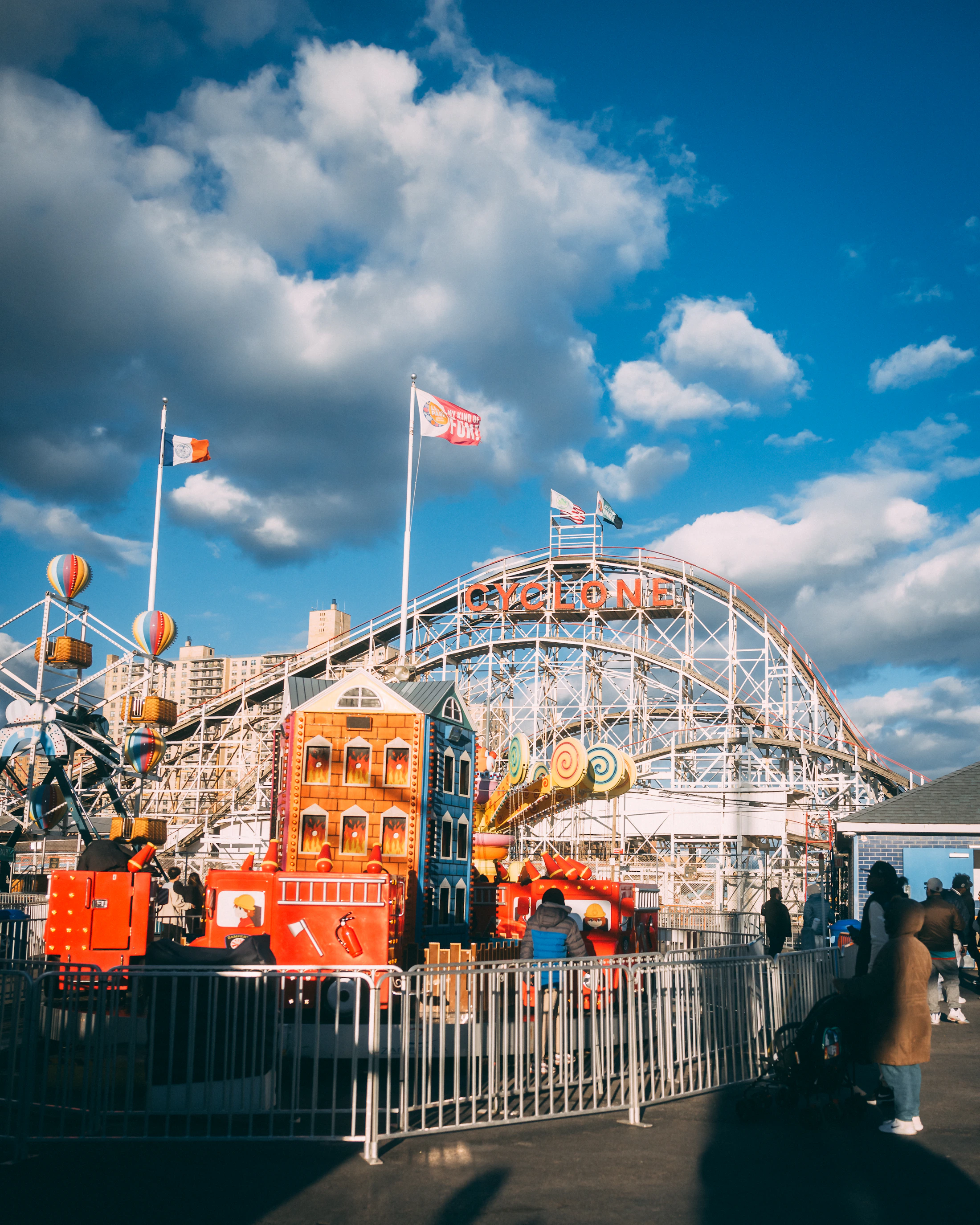 Roller coaster at an amusement park with visitors walking nearby