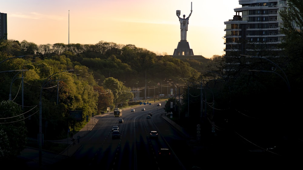 a view of a street with a statue in the background