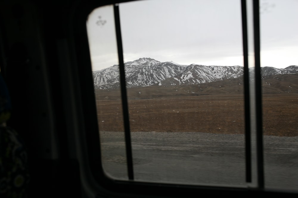 a view of a snowy mountain from a train window