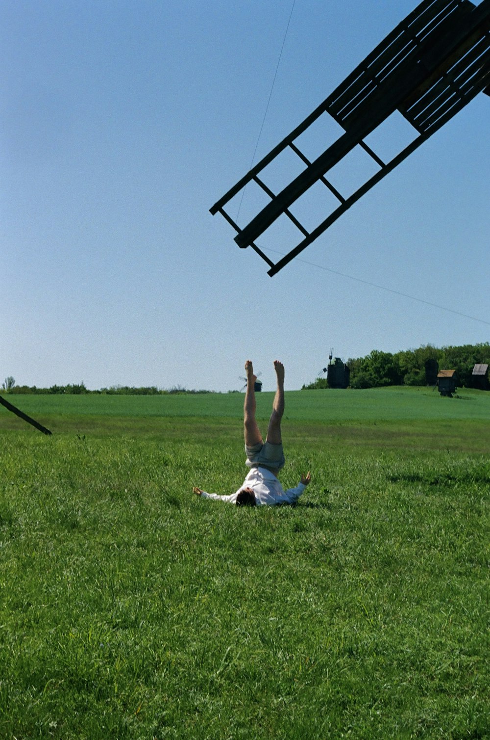 a person laying on the ground with a kite in the air