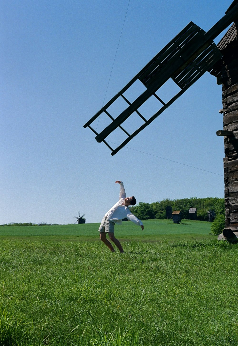 a man flying a kite over a lush green field