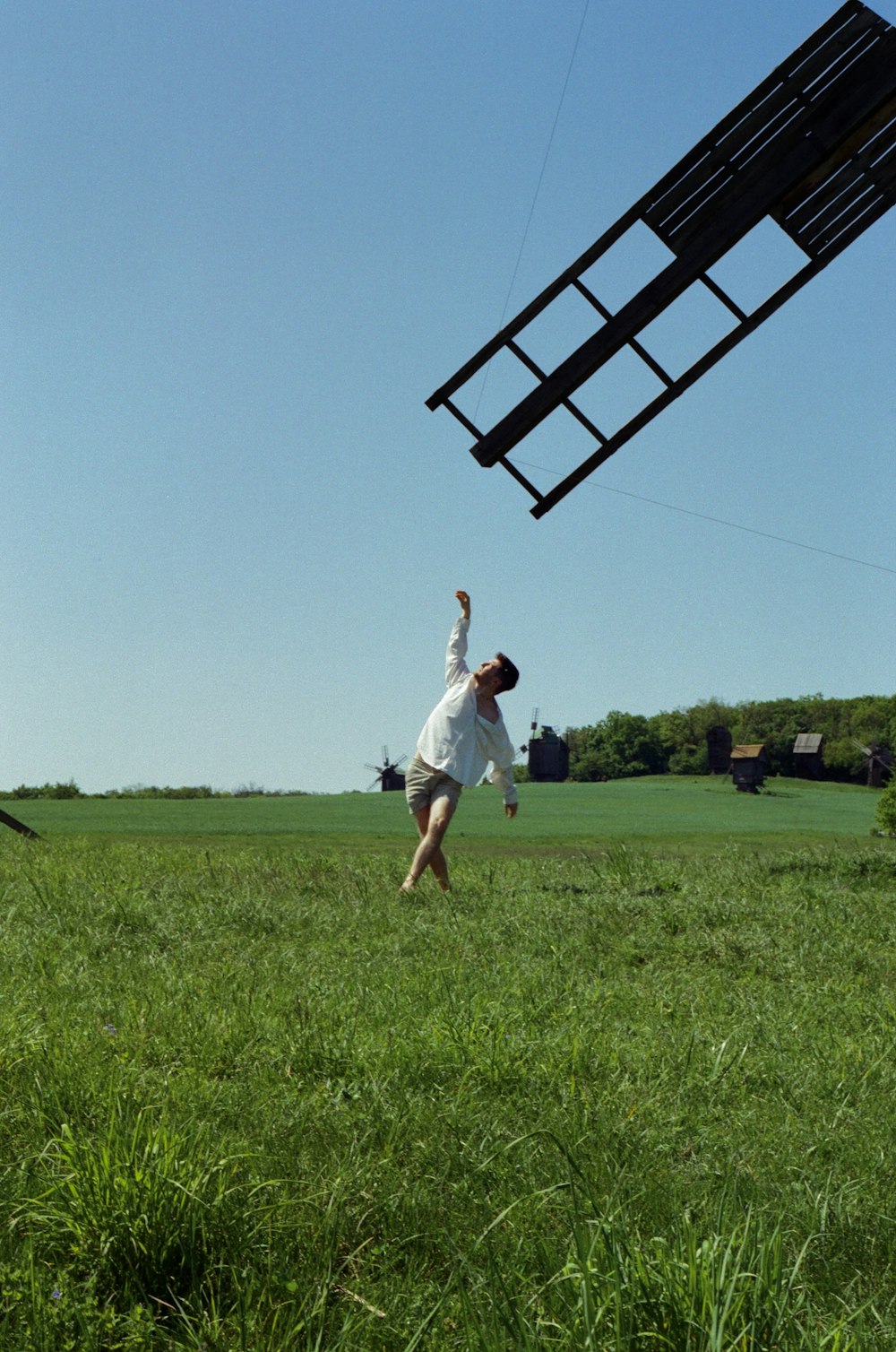 a man in a field flying a kite