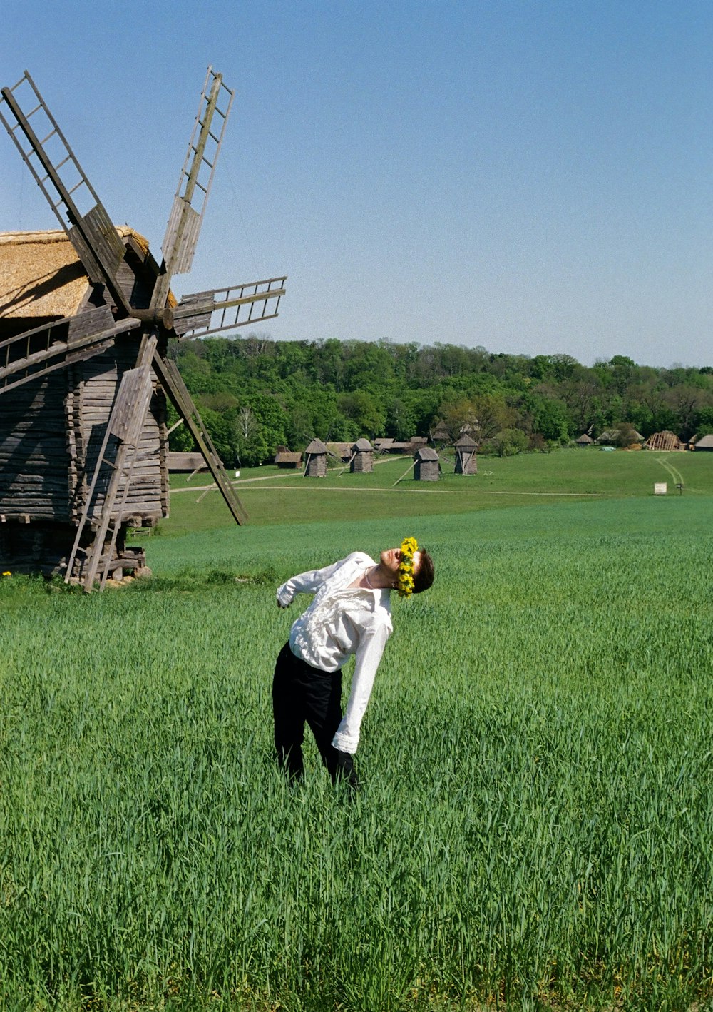 a person in a field with a windmill in the background
