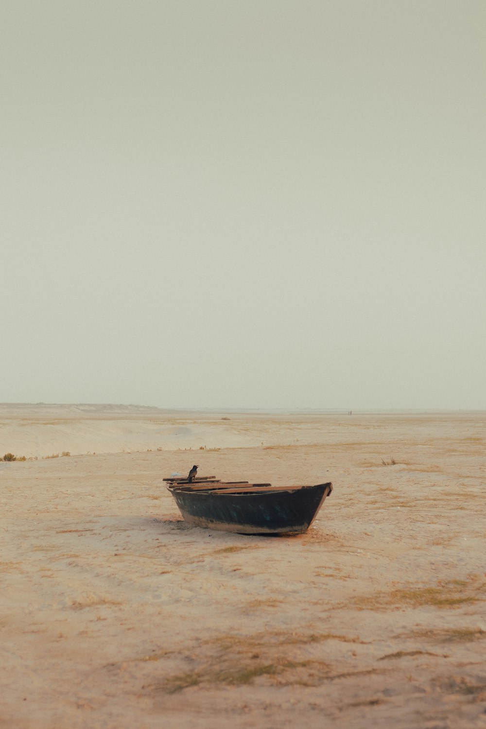 un petit bateau flottant sur une plage de sable