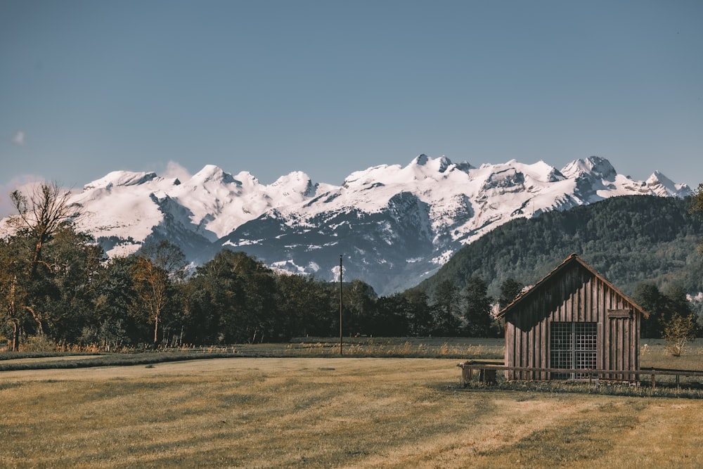 a barn in a field with mountains in the background