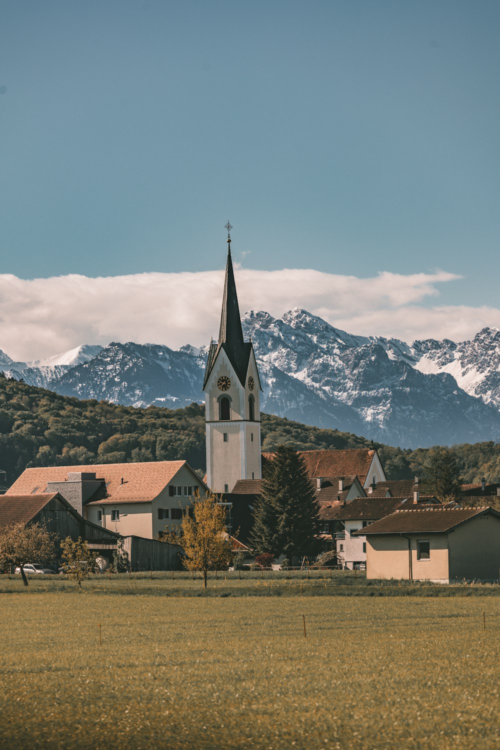 eine Kirche inmitten eines Feldes mit Bergen im Hintergrund