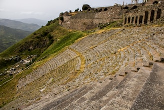 a large stone structure sitting on top of a lush green hillside