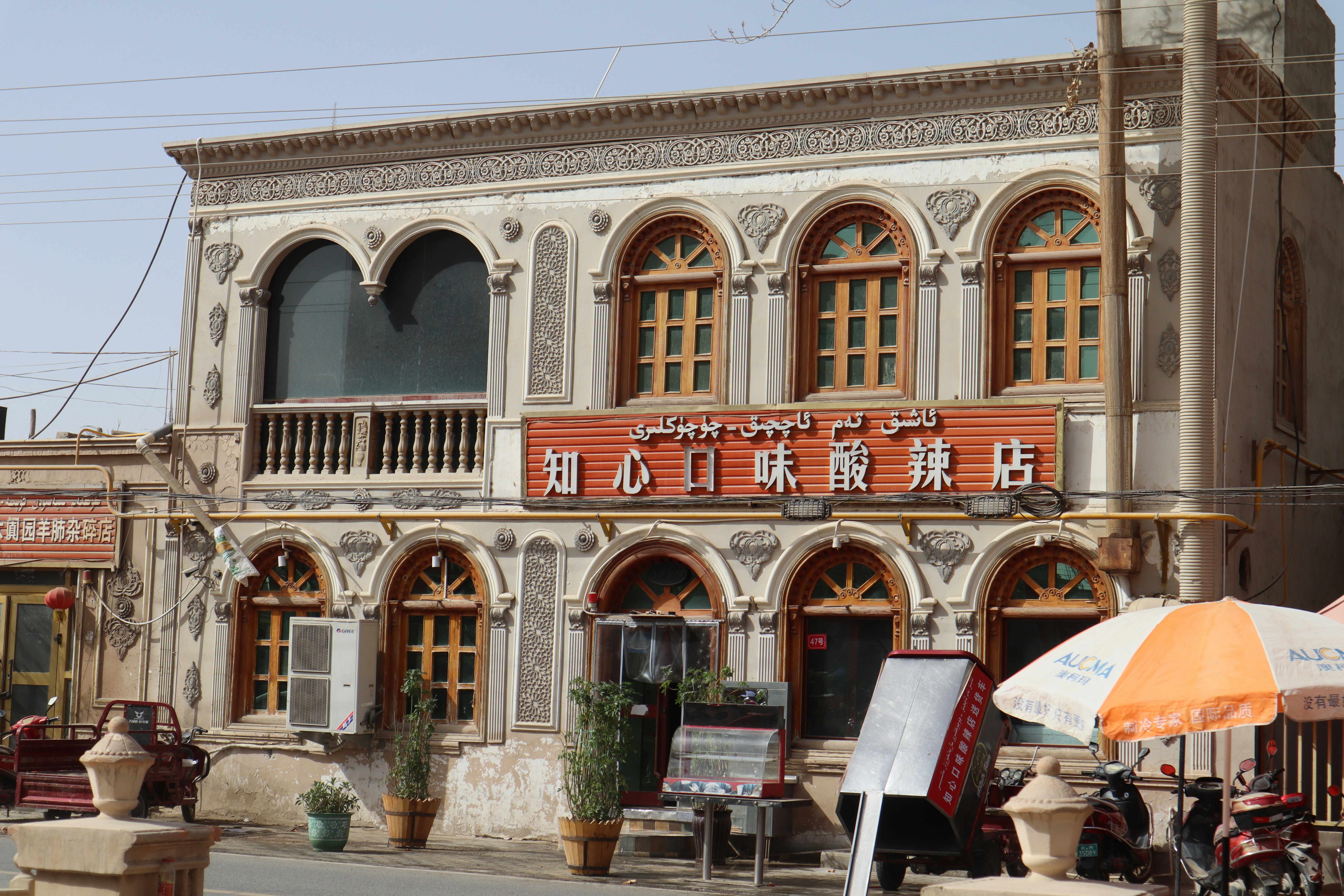 an old building with an orange and white umbrella in front of it