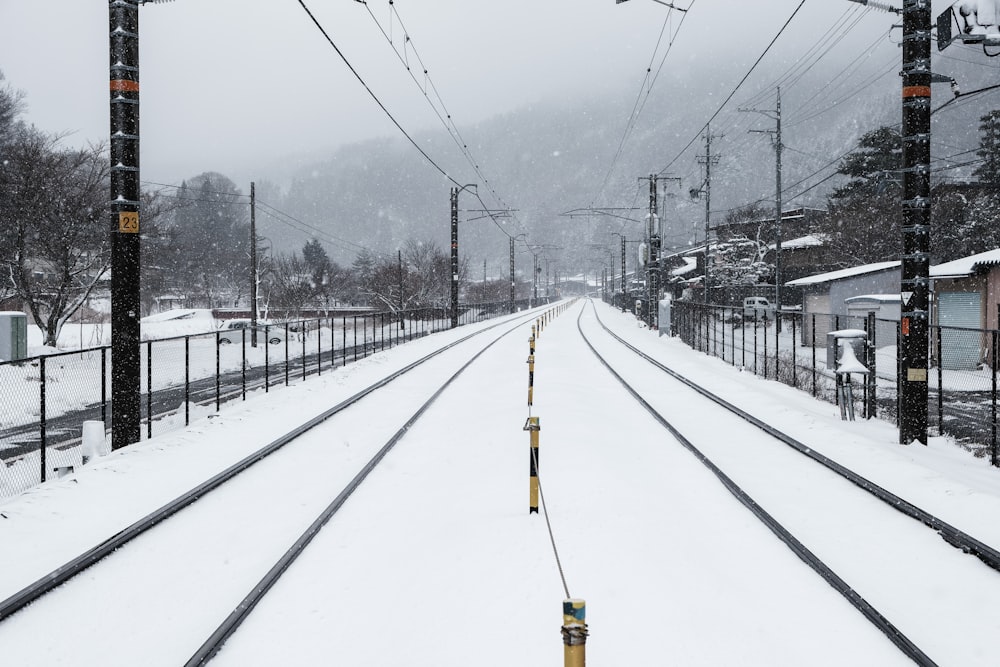 a train track covered in snow next to power lines