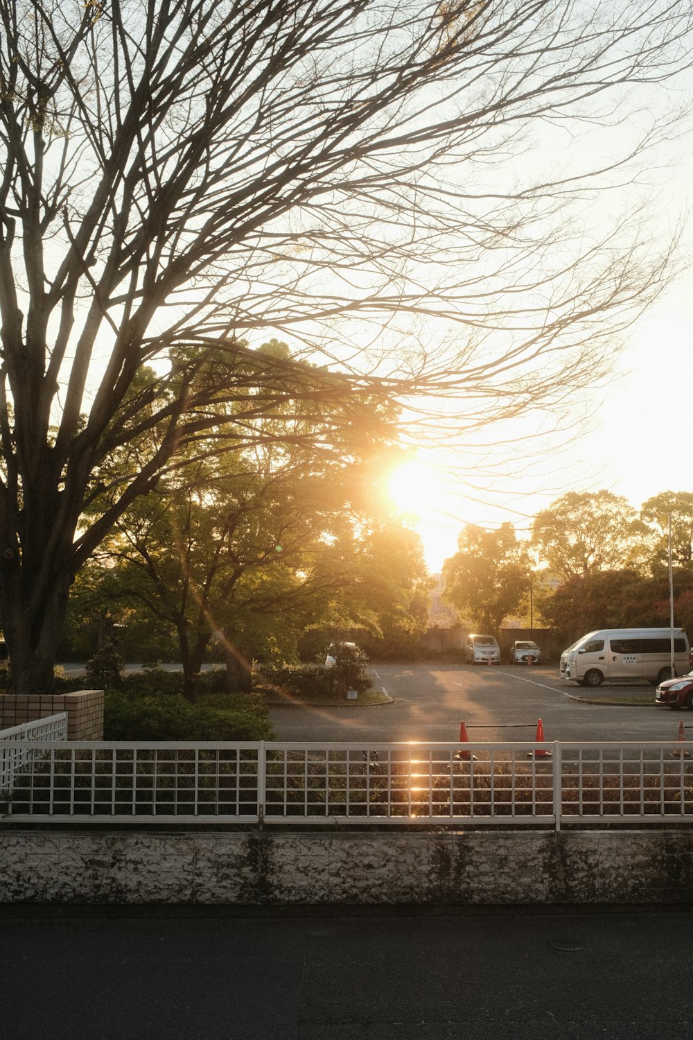 the sun is setting over a parking lot