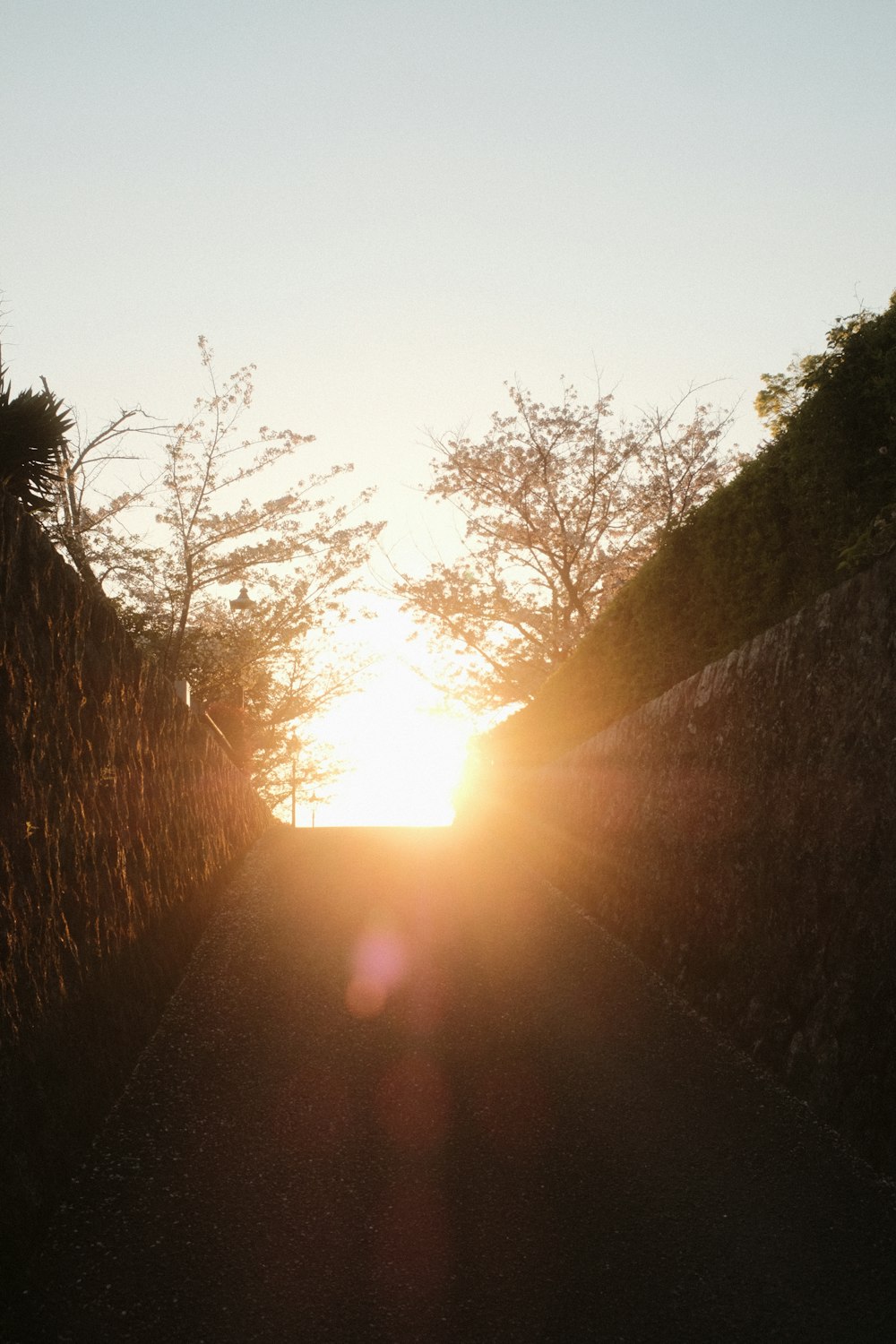 the sun is setting behind a stone wall