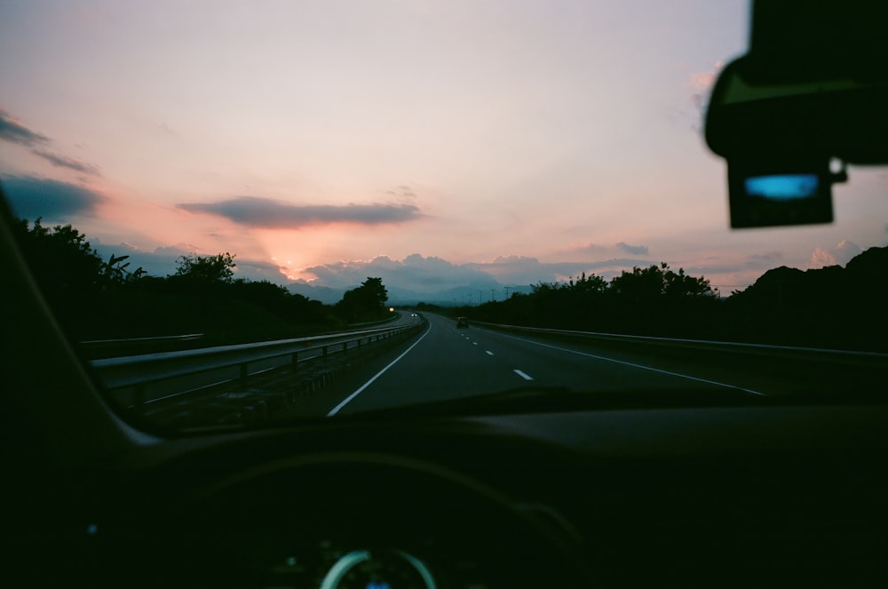 a car driving down a highway at dusk