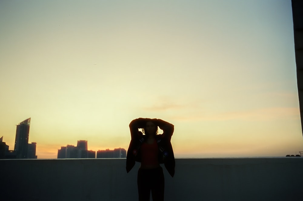 Eine Person, die bei Sonnenuntergang auf einem Dach steht