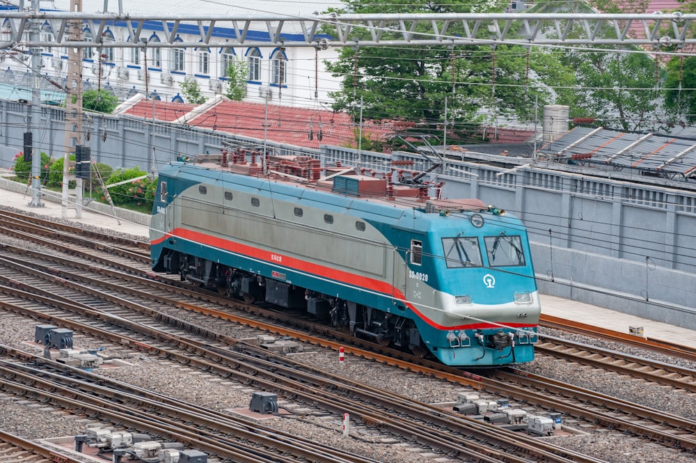 a blue and silver train traveling down train tracks