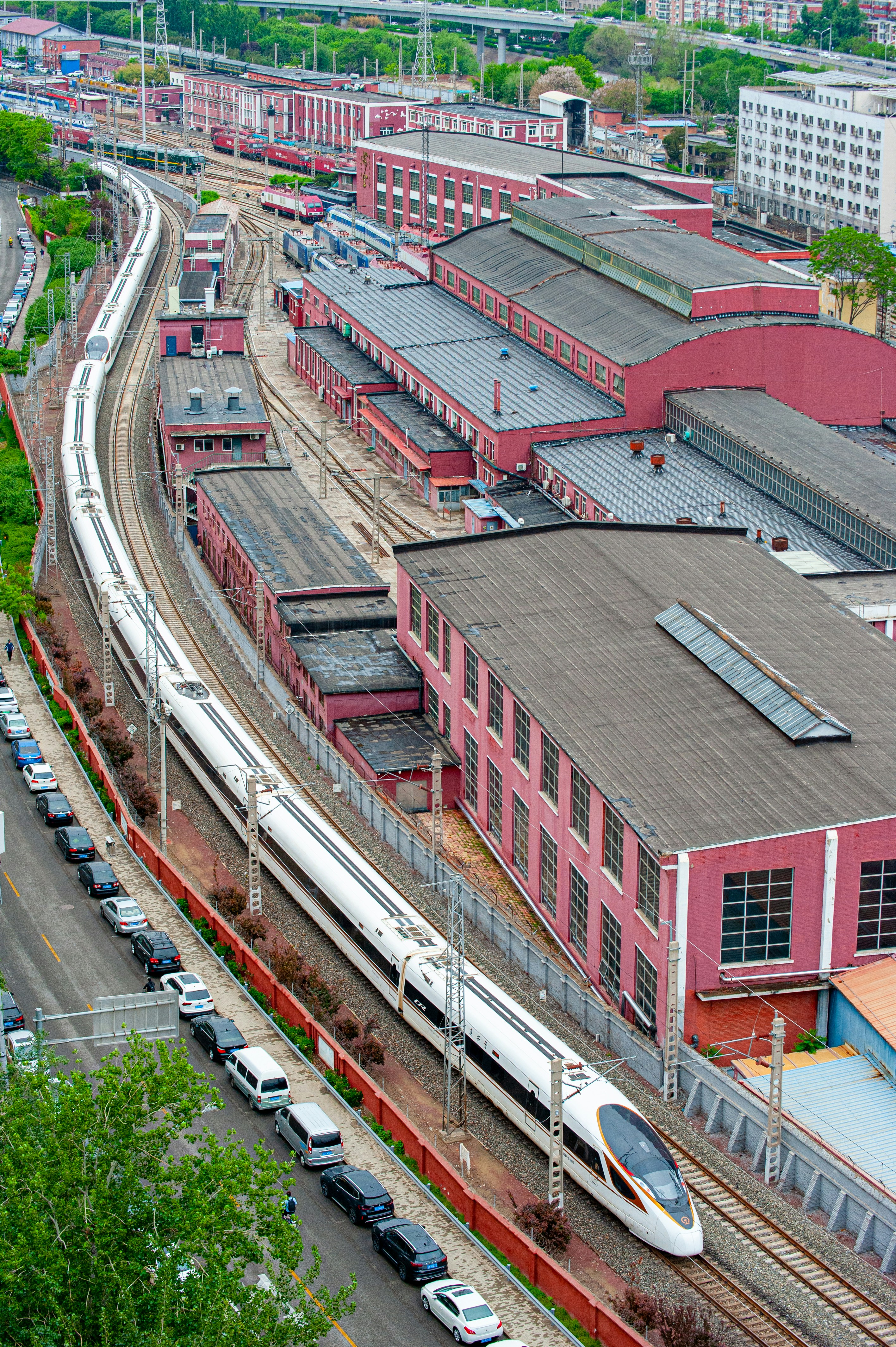 A train traveling past a train station next to tall buildings photo ...