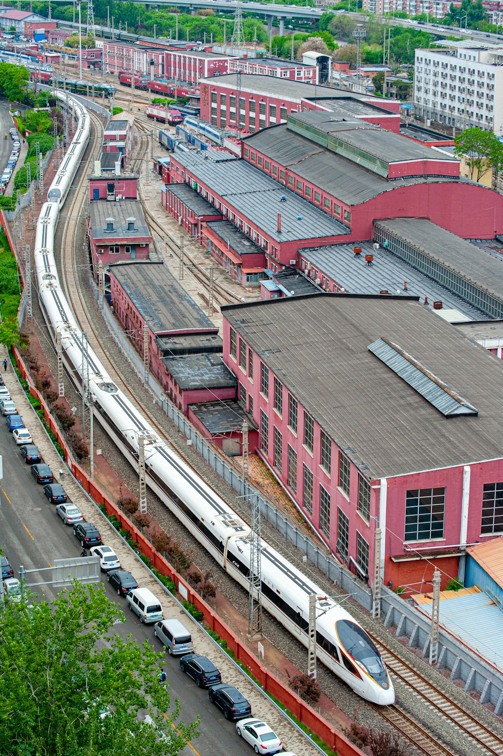 a train traveling past a train station next to tall buildings