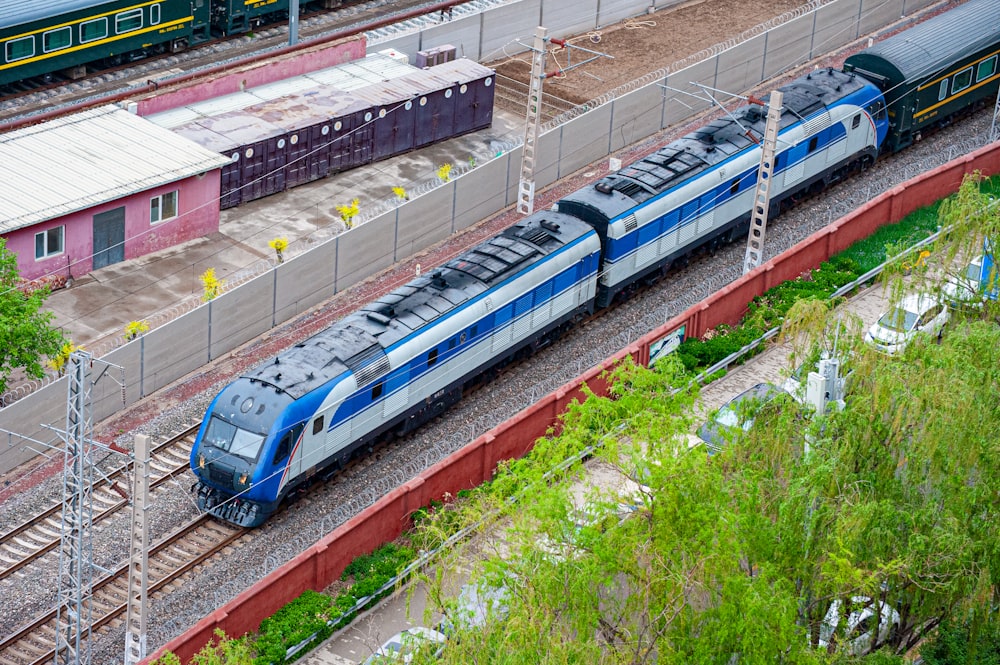 a blue and silver train traveling down train tracks