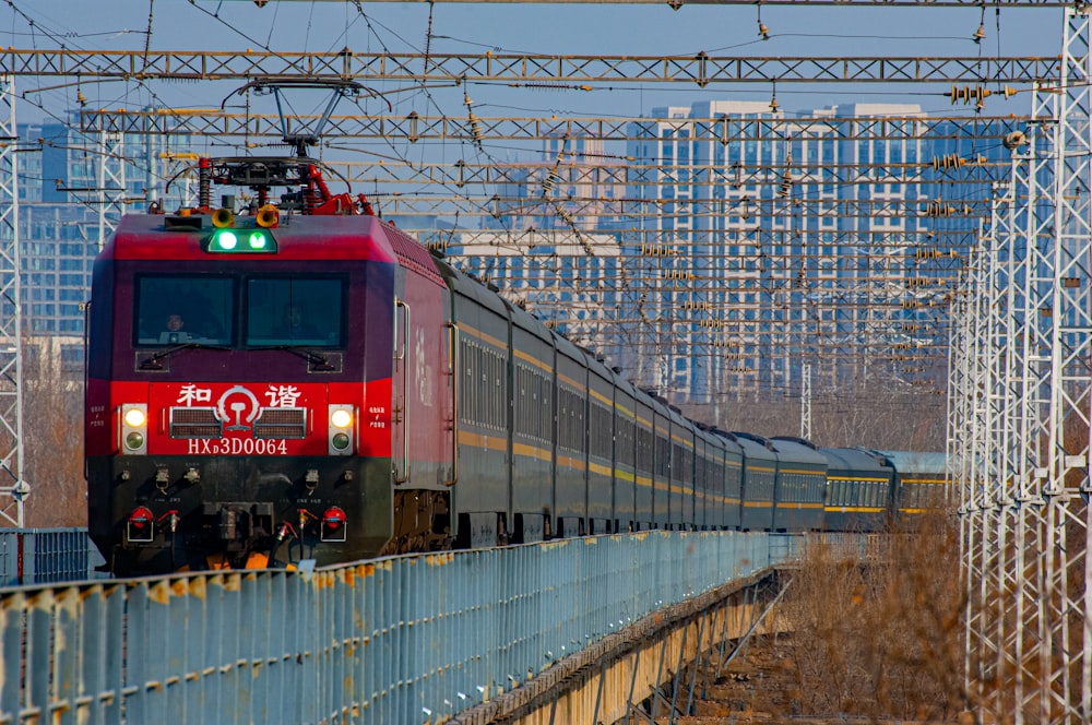 a red train traveling down tracks next to tall buildings