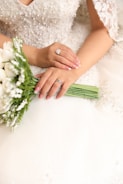 a woman in a wedding dress holding a bouquet of flowers