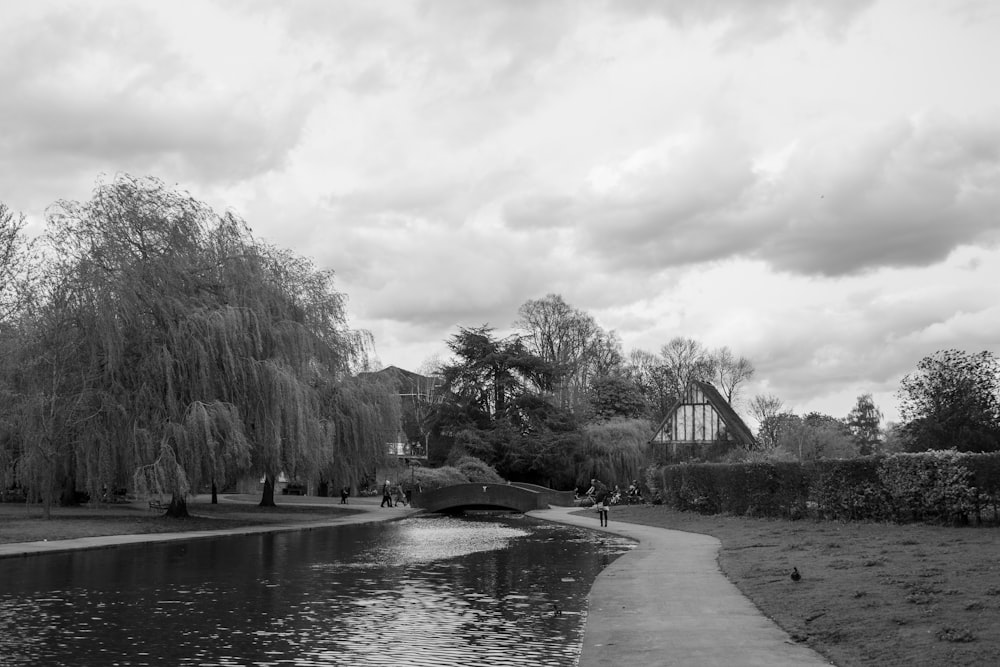 a black and white photo of a river and a bridge