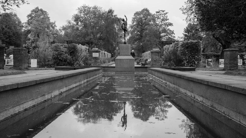 a black and white photo of a fountain in a park