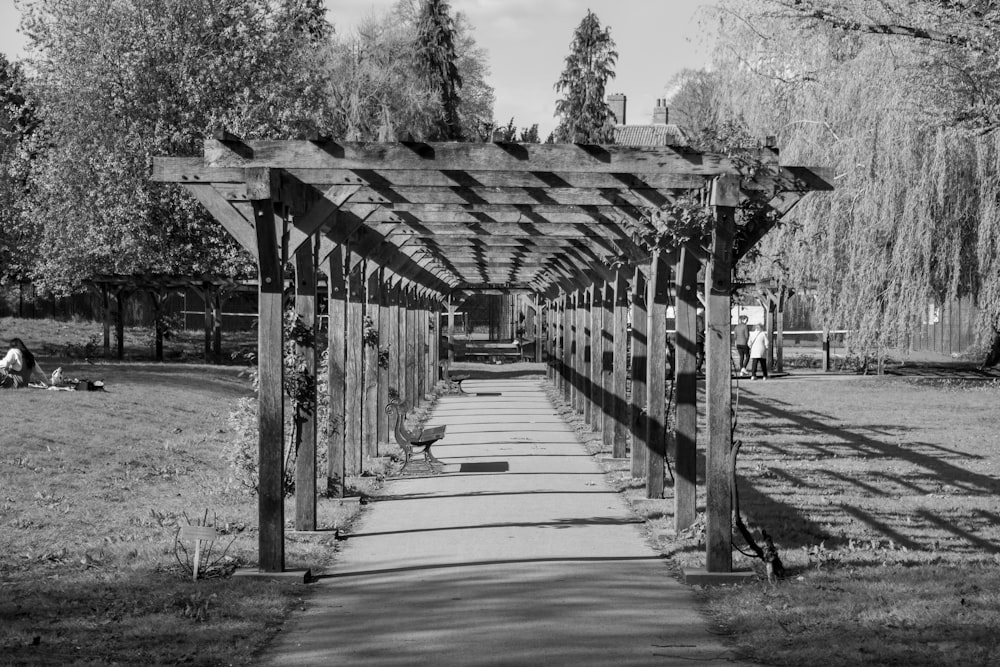 a black and white photo of a walkway in a park