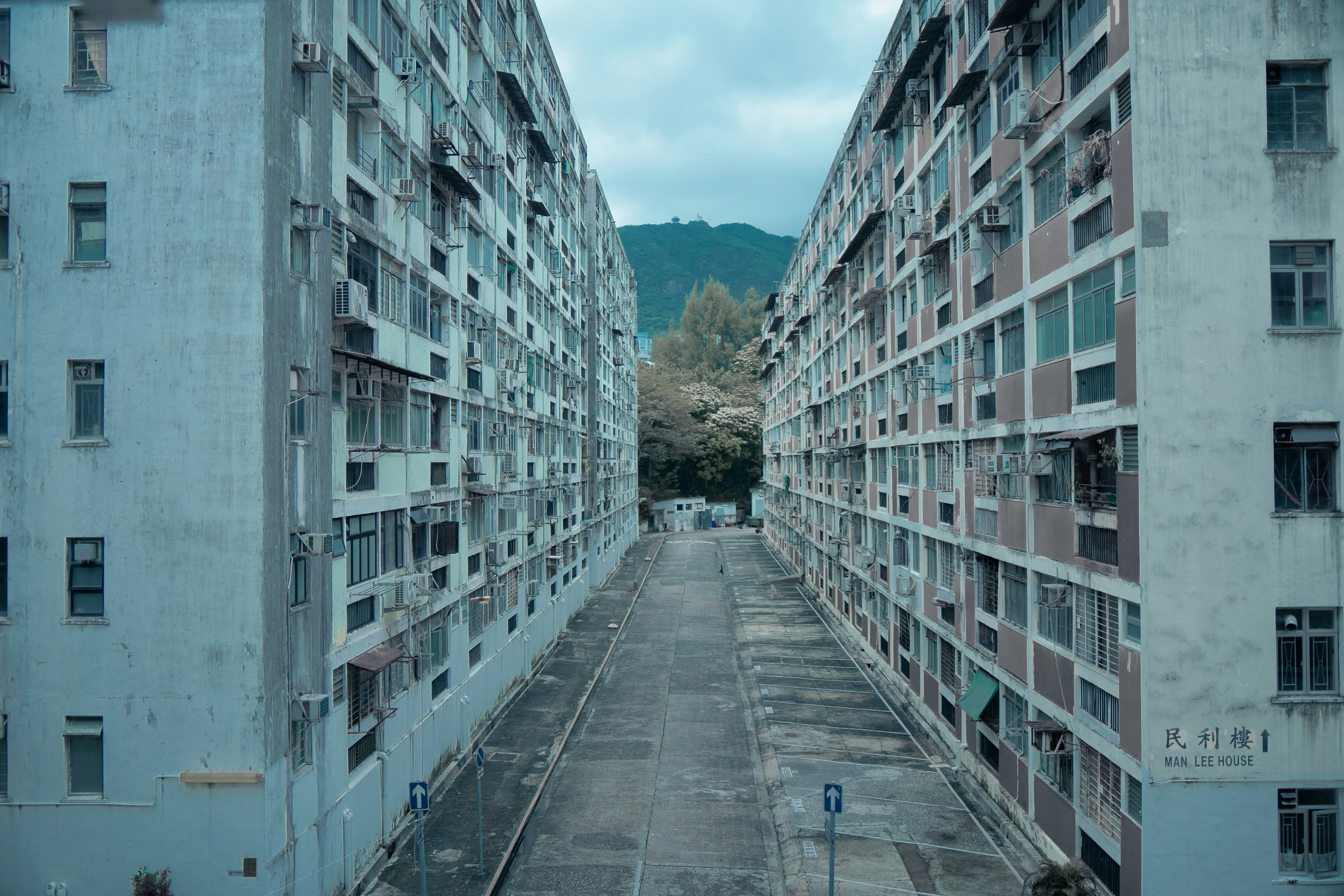 an empty street between two buildings with a mountain in the background