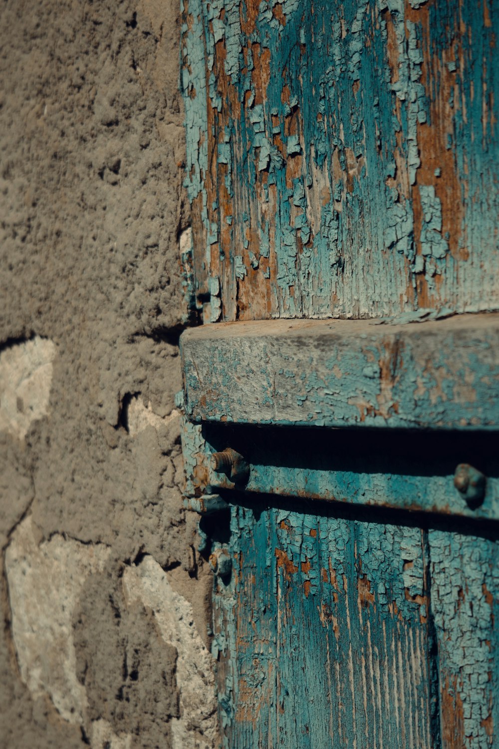 a close up of a wooden door with peeling paint