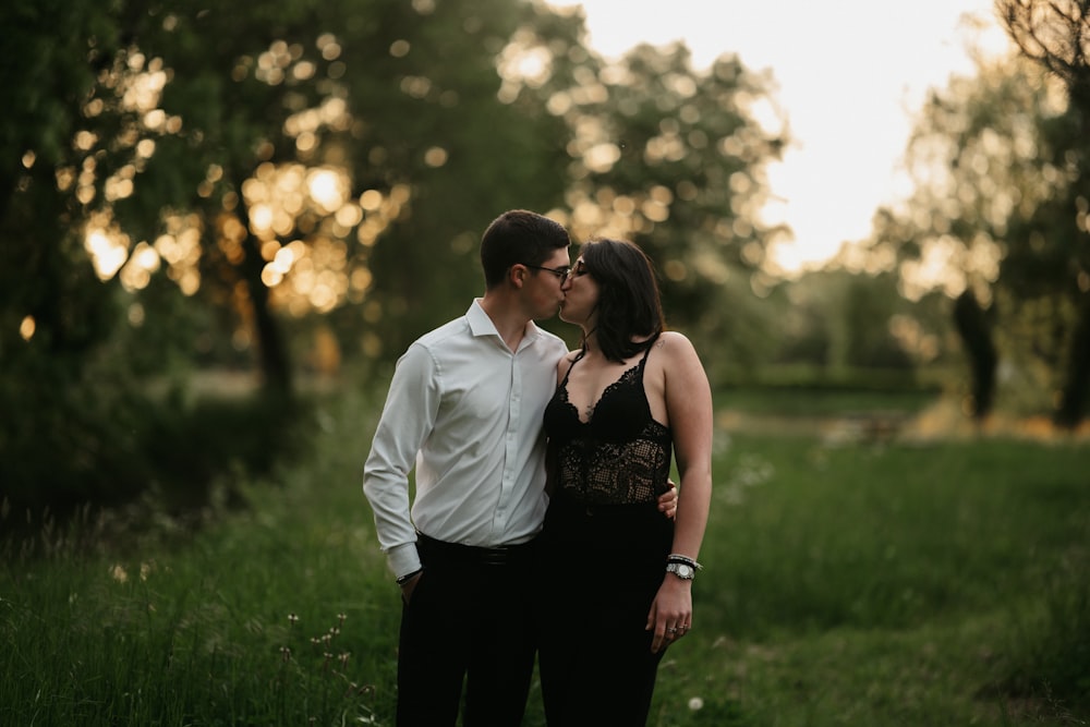 a man and a woman are standing in the grass