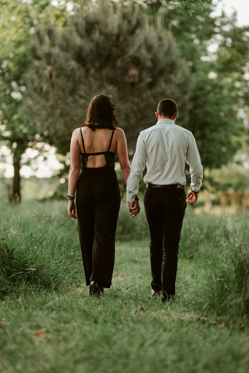 a man and a woman walking through a field