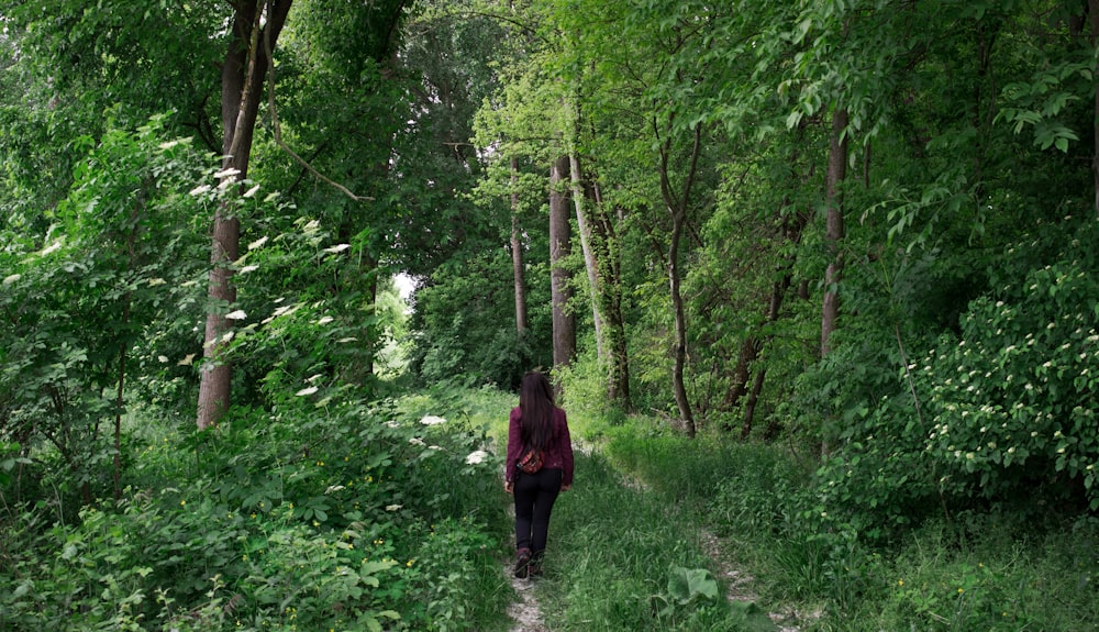 a woman walking down a path in the woods