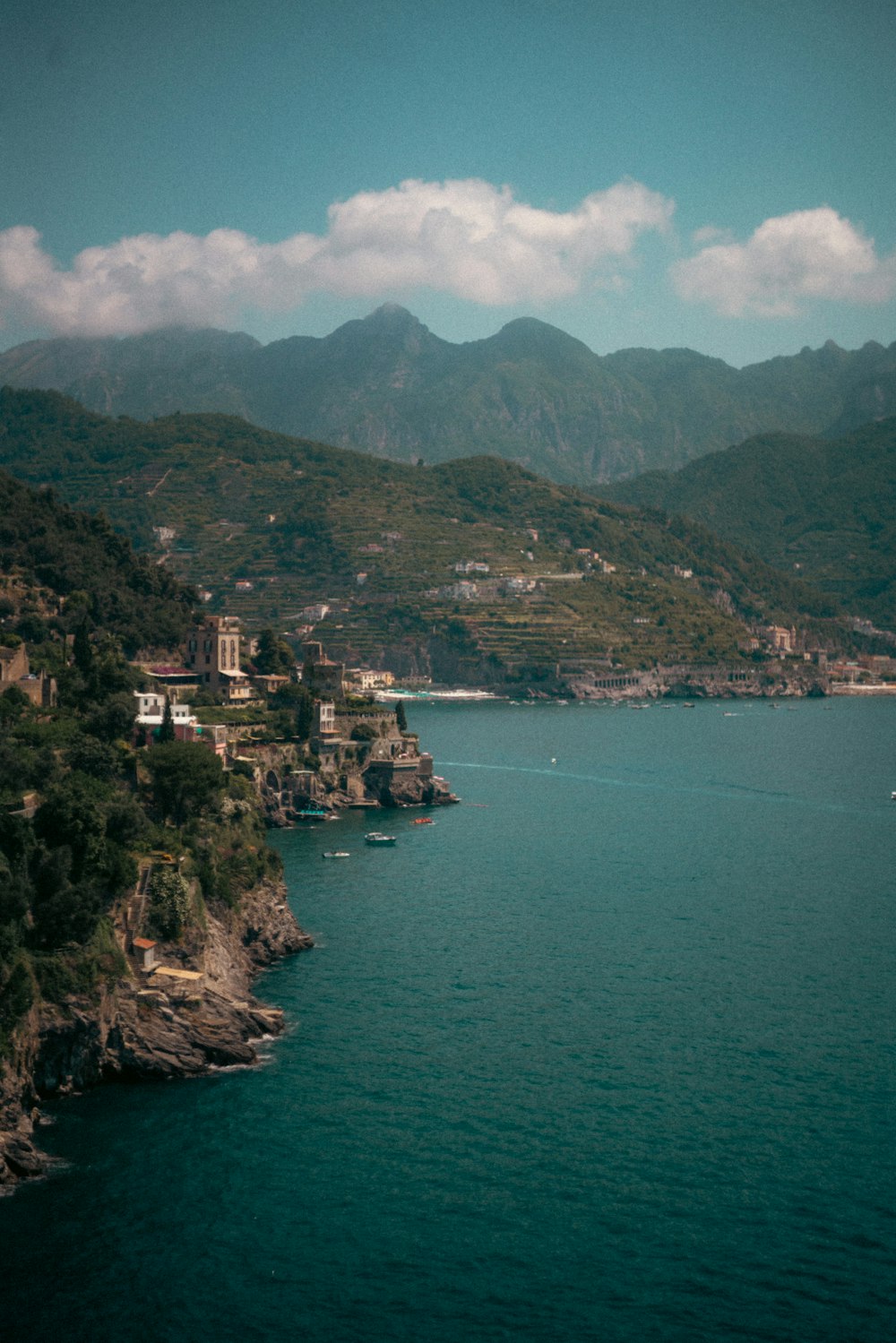 a body of water surrounded by mountains and houses