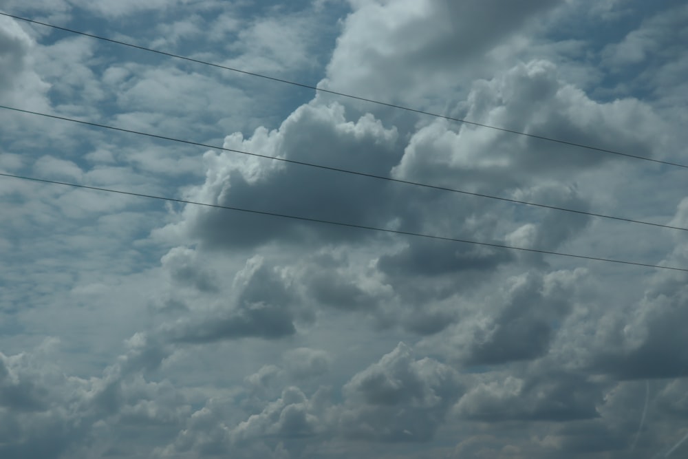 a cloudy sky with power lines in the foreground