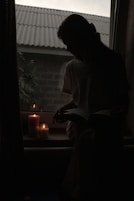 a woman sitting on a window sill reading a book