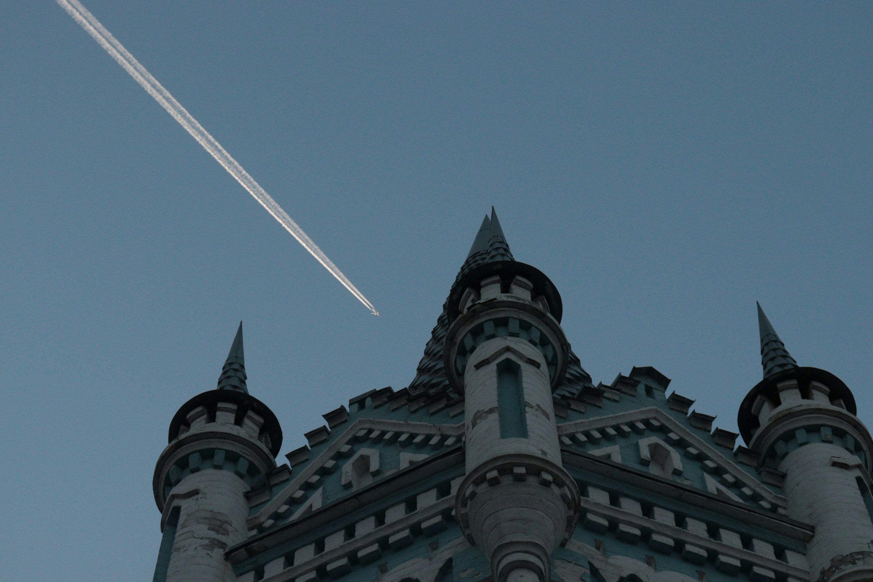 an airplane is flying over a castle like building