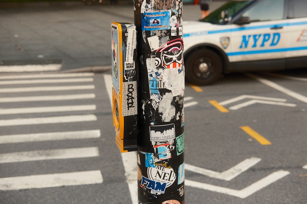 a parking meter covered in stickers on a city street