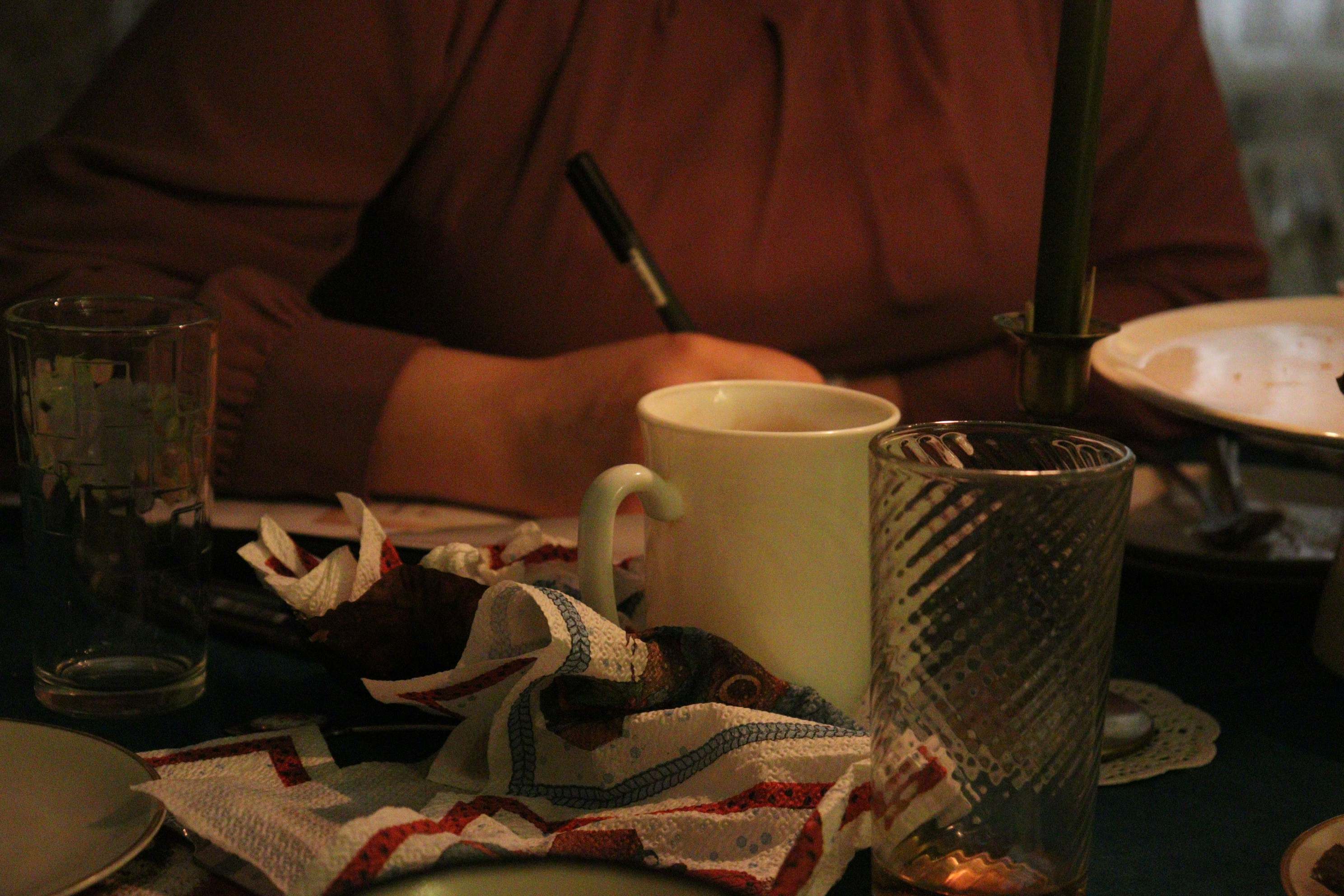a person sitting at a table with plates and cups